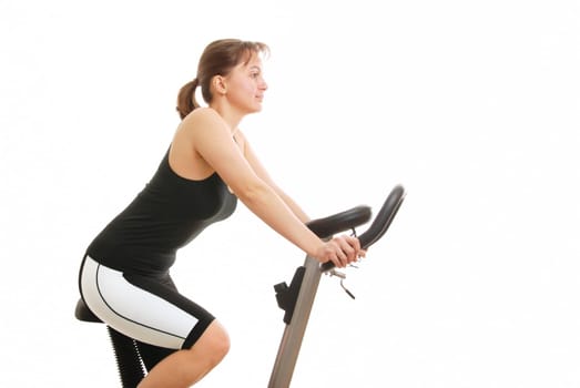 Isolated young womanexercising on a spinning bicycle - profile