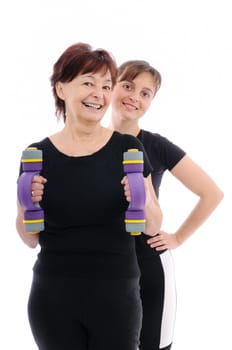 Senior woman  exercising with barbells assisted by trainer