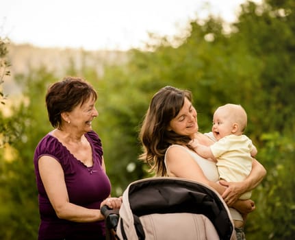Happy together - grandmother with her daughter and her granddaughter outdoor in nature