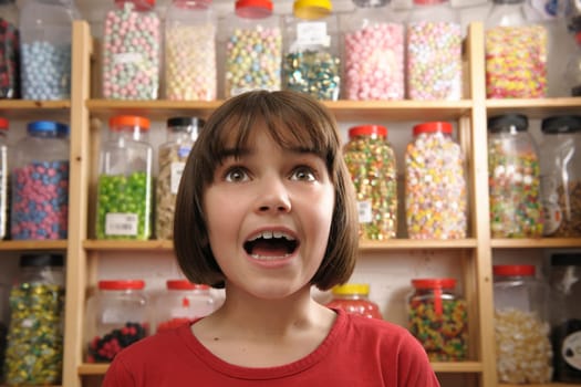 young girl looking in awe at rows of sweets