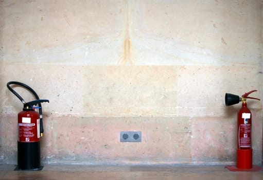 The photograph of two fire extinguishers on one wall.