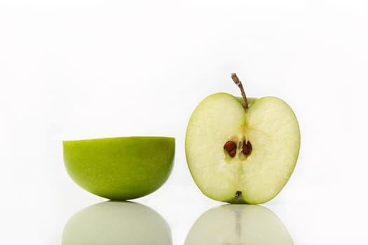 Studio shot of green apple cut in half showing seeds