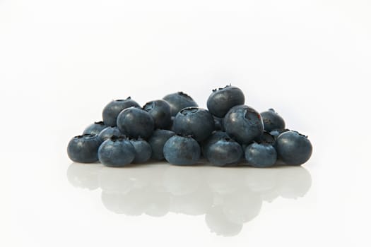 Studio shot of group of blueberries on white background with reflection