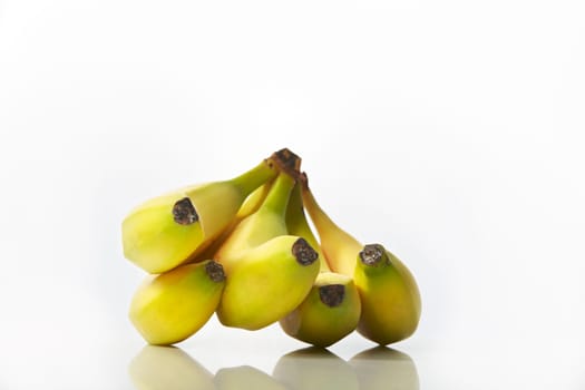 Studio shot of bunch of bananas on white background with reflection