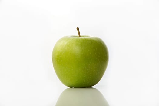 Studio shot of green apple on white background with reflection