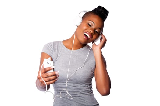 Beautiful young woman with headphones and mobile device listening grooving singing to music, isolated on white.