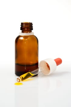 Orange with green leaves and a bottle with dropper isolated on a white background. Alternative medicine concept