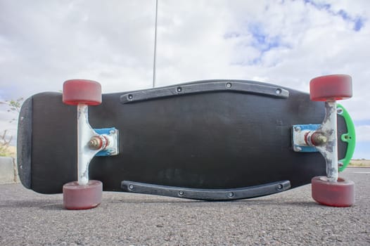Vintage Style Longboard Black Skateboard on an Empty Asphalt Desert Road