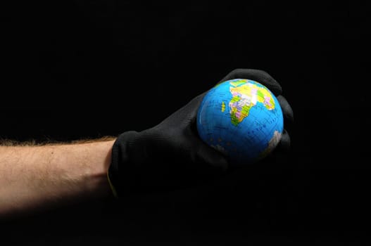 Planet Earth and Hand on a Black Background
