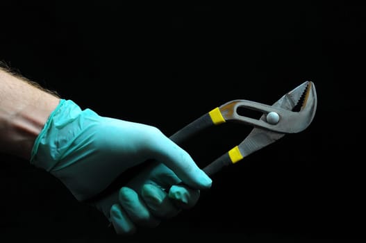 Pliers and Hand on a Black Background