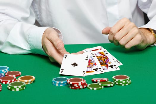 gambler. Male hand with cards and chips on green table