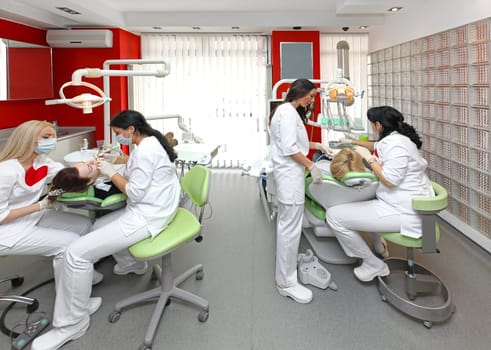 Dentists at work in modern dental office