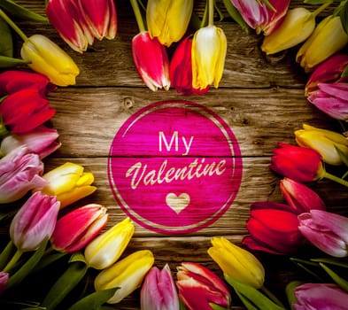 Romantic heart-shaped colourful tulip frame made of fresh flowers on a rustic wooden background for Valentines Day with a central - My Valentine - wish