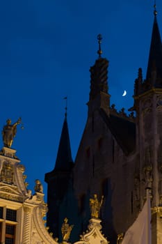 Towers and façade of Bruges Town Hall in the moonlight