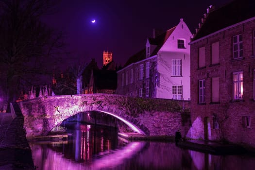 A canal in Bruges at night with illuminated bridges,shade radiand orchid