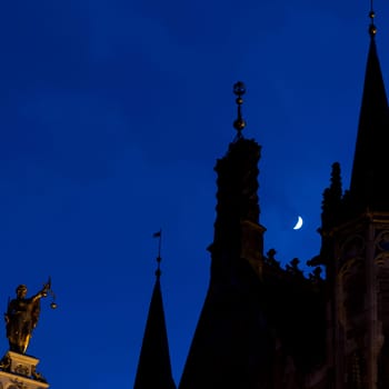 Towers and façade of Bruges Town Hall in the moonlight