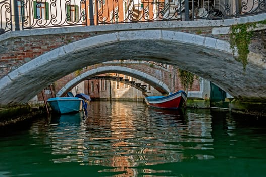 Boats and bridge over a canal in Venice, Italy.