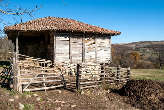 Old rural house with wood leaning against the wall