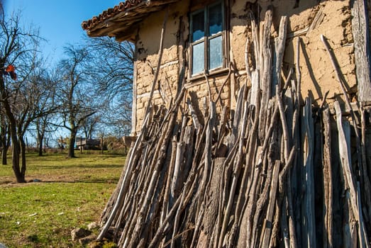 Old rural house with wood leaning against the wall