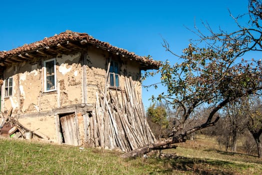 Old rural house with wood leaning against the wall