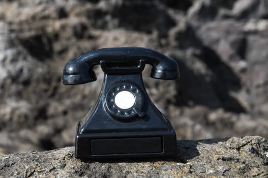 International Communications Vintage Telephone Toy on the Volcanic Rocks