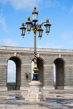Ornate gilded lamp post at the Royal Palace in Madrid, Spain .
