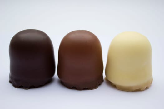 Chocolate covered dark brown, light brown and white marshmallows.