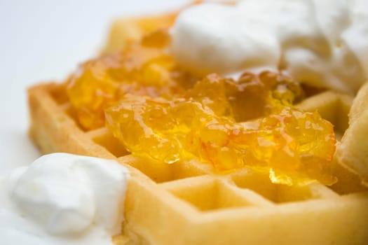 Toasted waffles with orange jam and cream on top.