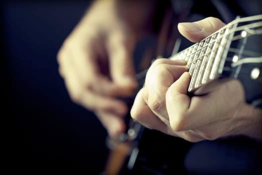 Close up on hands playing on electric guitar