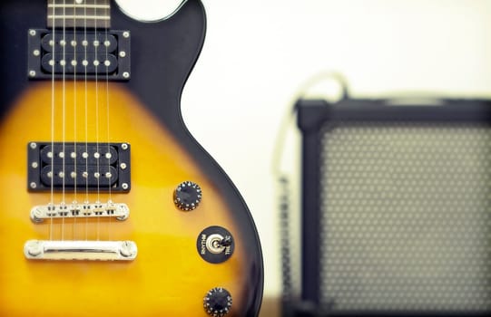 Guitar with amplifier in the background