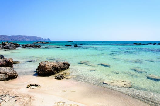 Elafonisi or Elafonissi, "deer island"" in Greek, is an island located close to the southwestern corner of the Mediterranean island of Crete, Greece. Elafonisi is an oblong, which often ""breaks"" in two parts by water giving the impression of being a separate island. The island is a protected nature reserve."