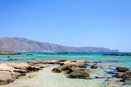 Elafonisi or Elafonissi, "deer island"" in Greek, is an island located close to the southwestern corner of the Mediterranean island of Crete, Greece. Elafonisi is an oblong, which often ""breaks"" in two parts by water giving the impression of being a separate island. The island is a protected nature reserve."
