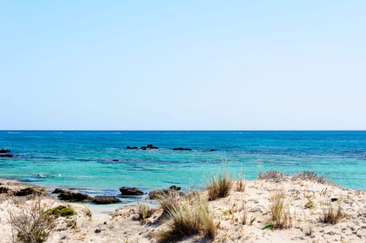 Elafonisi or Elafonissi, "deer island"" in Greek, is an island located close to the southwestern corner of the Mediterranean island of Crete, Greece. Elafonisi is an oblong, which often ""breaks"" in two parts by water giving the impression of being a separate island. The island is a protected nature reserve."