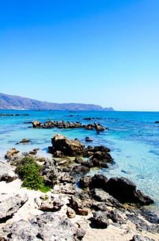 Elafonisi or Elafonissi, "deer island"" in Greek, is an island located close to the southwestern corner of the Mediterranean island of Crete, Greece. Elafonisi is an oblong, which often ""breaks"" in two parts by water giving the impression of being a separate island. The island is a protected nature reserve."