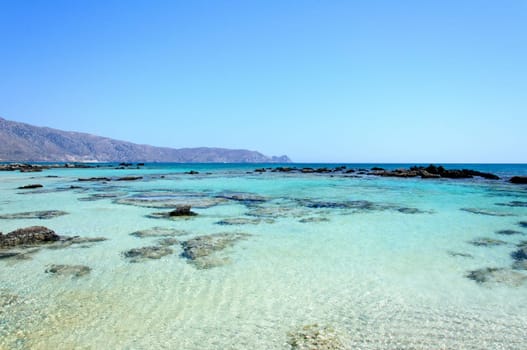 Elafonisi or Elafonissi, "deer island"" in Greek, is an island located close to the southwestern corner of the Mediterranean island of Crete, Greece. Elafonisi is an oblong, which often ""breaks"" in two parts by water giving the impression of being a separate island. The island is a protected nature reserve."