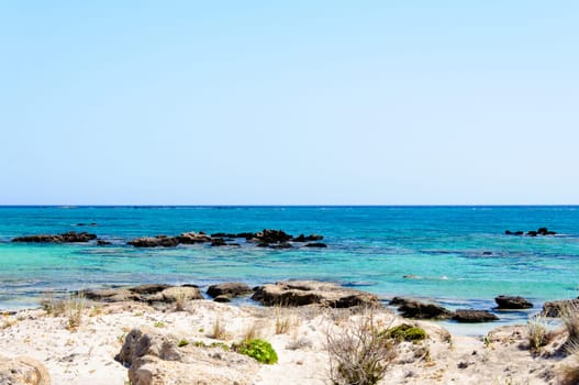 Elafonisi or Elafonissi, "deer island"" in Greek, is an island located close to the southwestern corner of the Mediterranean island of Crete, Greece. Elafonisi is an oblong, which often ""breaks"" in two parts by water giving the impression of being a separate island. The island is a protected nature reserve."