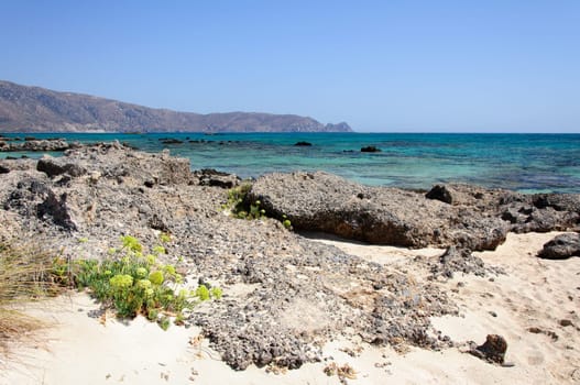 Elafonisi or Elafonissi, "deer island"" in Greek, is an island located close to the southwestern corner of the Mediterranean island of Crete, Greece. Elafonisi is an oblong, which often ""breaks"" in two parts by water giving the impression of being a separate island. The island is a protected nature reserve."