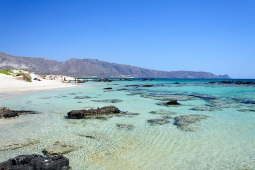 Elafonisi or Elafonissi, "deer island"" in Greek, is an island located close to the southwestern corner of the Mediterranean island of Crete, Greece. Elafonisi is an oblong, which often ""breaks"" in two parts by water giving the impression of being a separate island. The island is a protected nature reserve."