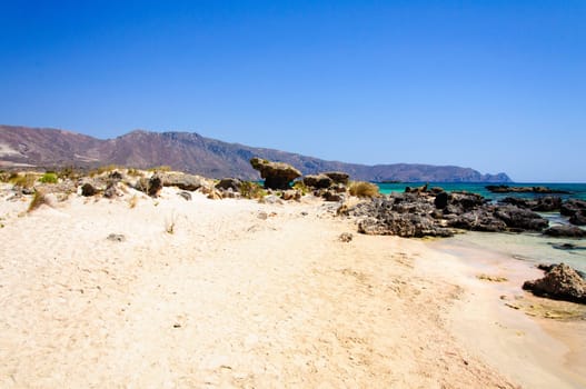 Elafonisi or Elafonissi, "deer island"" in Greek, is an island located close to the southwestern corner of the Mediterranean island of Crete, Greece. Elafonisi is an oblong, which often ""breaks"" in two parts by water giving the impression of being a separate island. The island is a protected nature reserve."