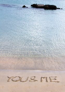 You and me message written in the sand on a beautiful  beach