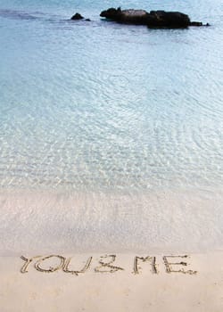 You and me message written in the sand on a beautiful  beach