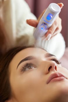 cosmetologist using primer spray for eyelash extension procedure in salon