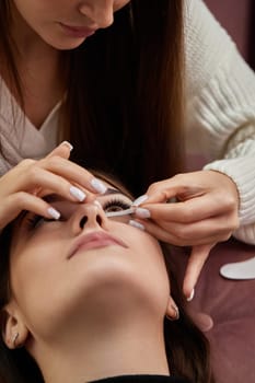 master preparing glue cotton tape under eye before eyelash extension procedure