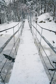 Beauty winter landscape with bridge fair trees and river under the snow.
