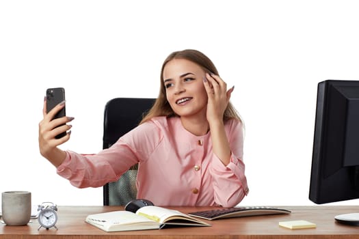 happy beautiful young woman in pink shirt takes selfie in office