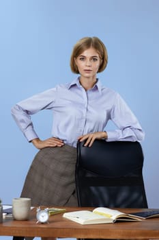 Young beautiful blonde business woman looking at the camera on blue background