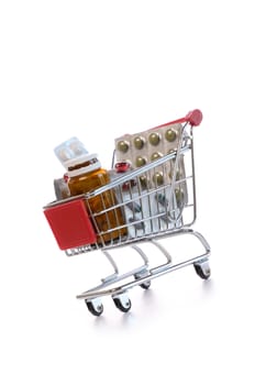 Shopping cart with pills and medicine isolated on white