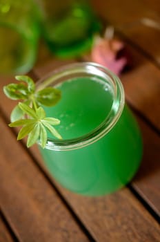 Woodruff liqueur on a wooden table
