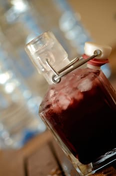 Cold bottle with juice of cherries and chrushed ice cubes