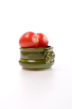 Fresh red roma tomatoes in a green ceramic bowl
